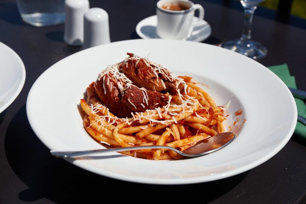 Freshly served in the restaurant pastitsada of beef with bucatini pasta. The most famous and characteristic dish from the island of Corfu in Greece.