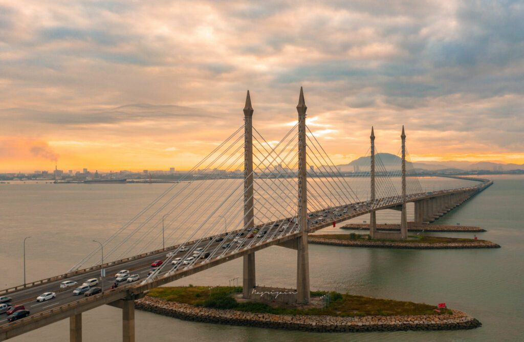 Aerial dramatic sunrise view with traffic at first Penang Bridge, Malaysia.